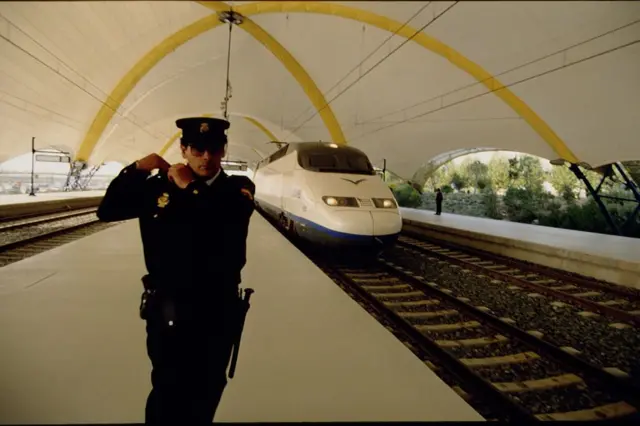 Un policía español, junto a un tren de la primera línea de alta velocidad (Madrid-Sevilla), inaugurada en 1992.