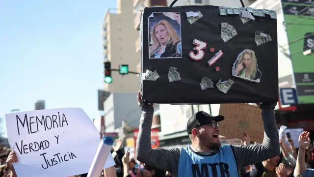 Un hombre sostiene un cartel en el que hace referencia al supuesto 3% que recibiría karina milei por los pagos de Andis a Suizo Argentina.