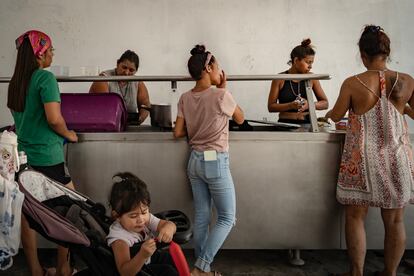 Mujeres entregan alimentos a las decenas de migrantes que se alojan en el albergue Pumarejo, en Matamoros.