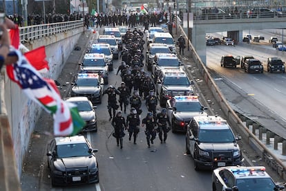 Decenas de policías bajan por una rampa de la autopista 101, cerca del centro de detención metropolitano del centro angelino.
