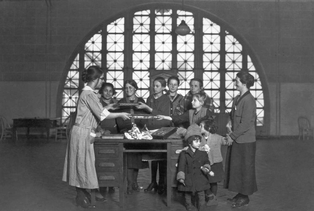 Funcionarias de Ellis Island reparten regalos navideños a niñas migrantes en 1926