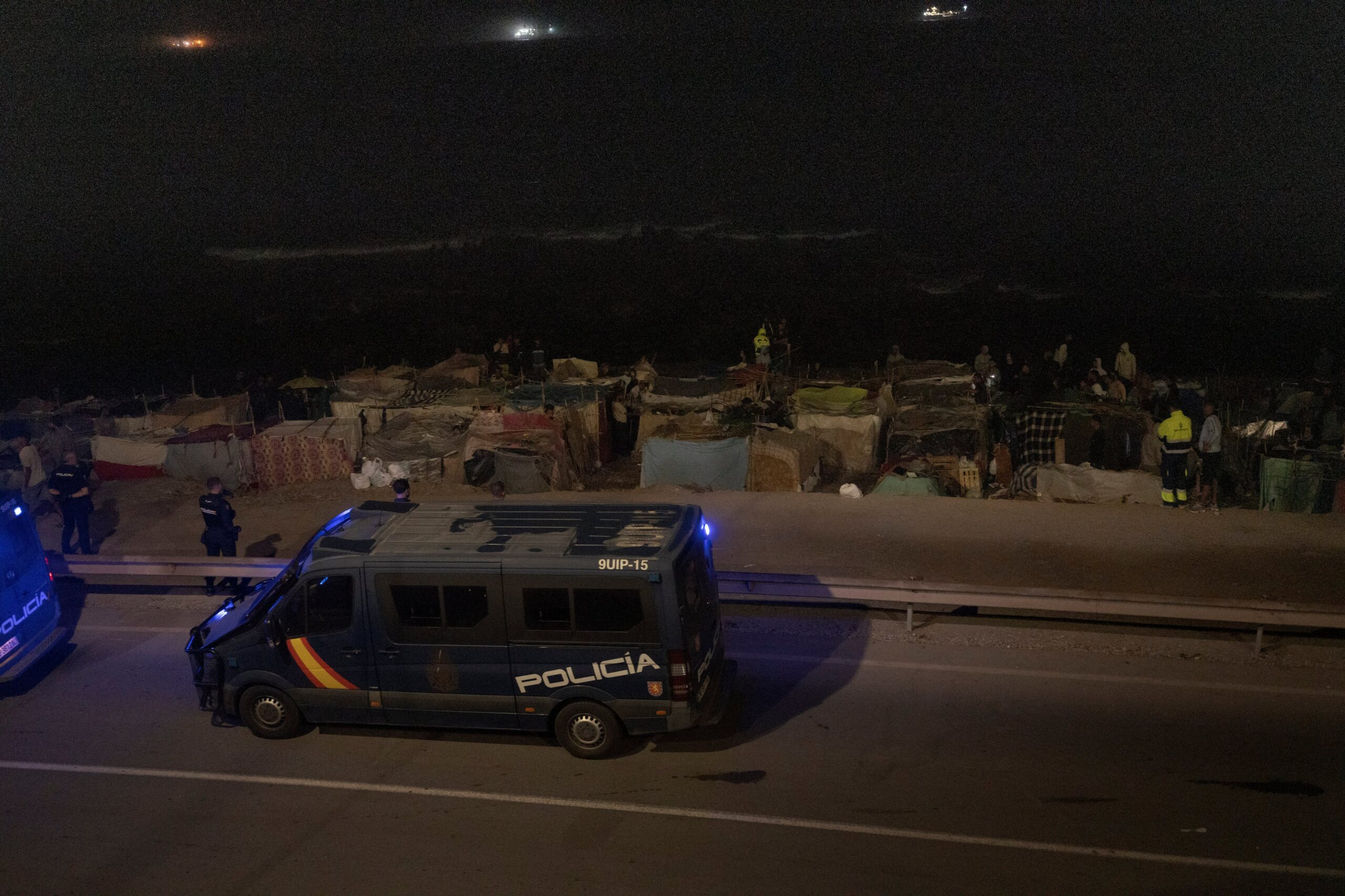 Dos furgoneta de la policía Nacional, frente a los asentamientos de la playa del Trampolín en la madrugada del 14 al 15 de septiembre.
