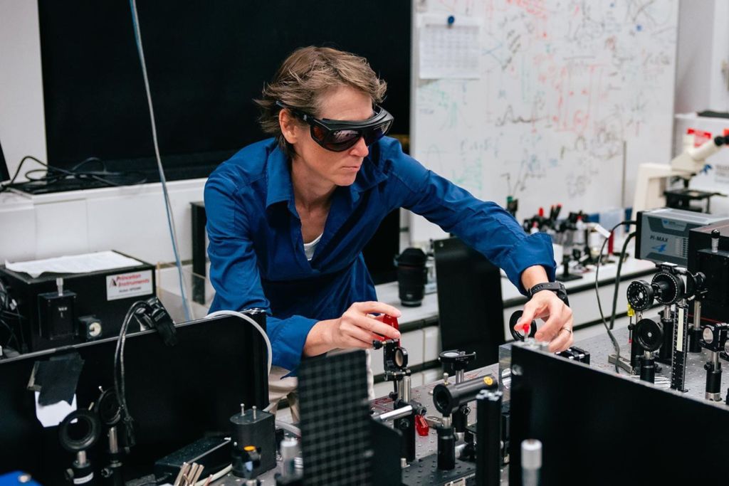 La estudiante de doctorado Eksha Chaudhary con la configuración de espectroscopia vibracional correlacionada