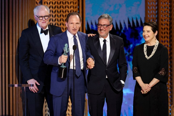 John Lithgow, Ralph Fiennes, Sergio Castellitto, abrazaditos o tomados de la mano, e Isabella Rossellini al aceptar el premio al mejor elenco. Foto Reuters