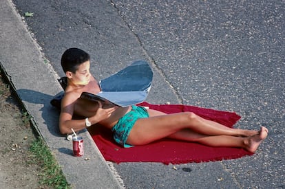 Una mujer tomando el sol en los años ochenta en las calles de París; sostiene en las manos un espejo para multiplicar el daño.