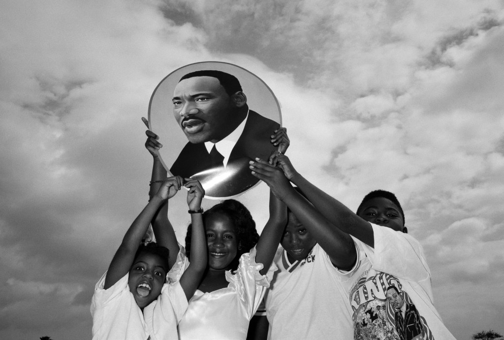 Niños y niñas posan con una imagen de Luther King en 1990