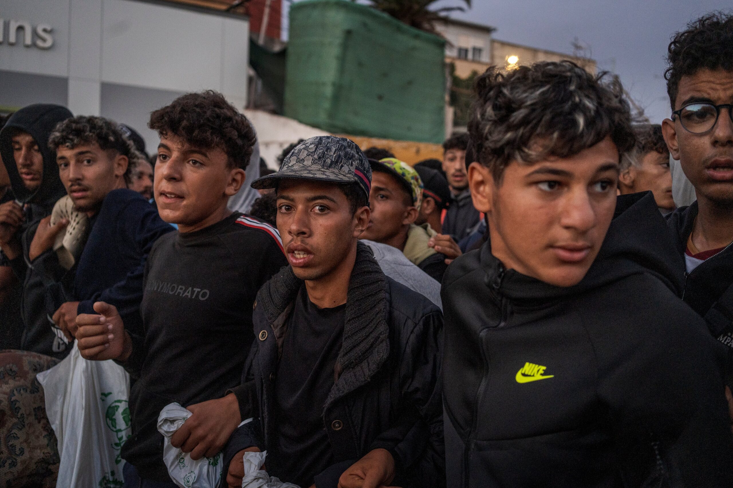 Traslado de migrantes que dormían en la calle a un espacio para acogerles, este domingo en Ceuta.