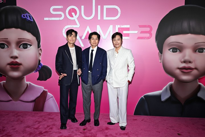 Los actores Lee Jung-jae y Lee Byung-hun rodean al creador de la serie, Hwang Dong-hyuk, en la première en The Plaza Hotel en New York. Foto AP