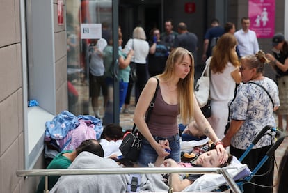 Una mujer acompaña a un paciente del hospital pediátrico atacado por misiles rusos, este lunes en Kiev.