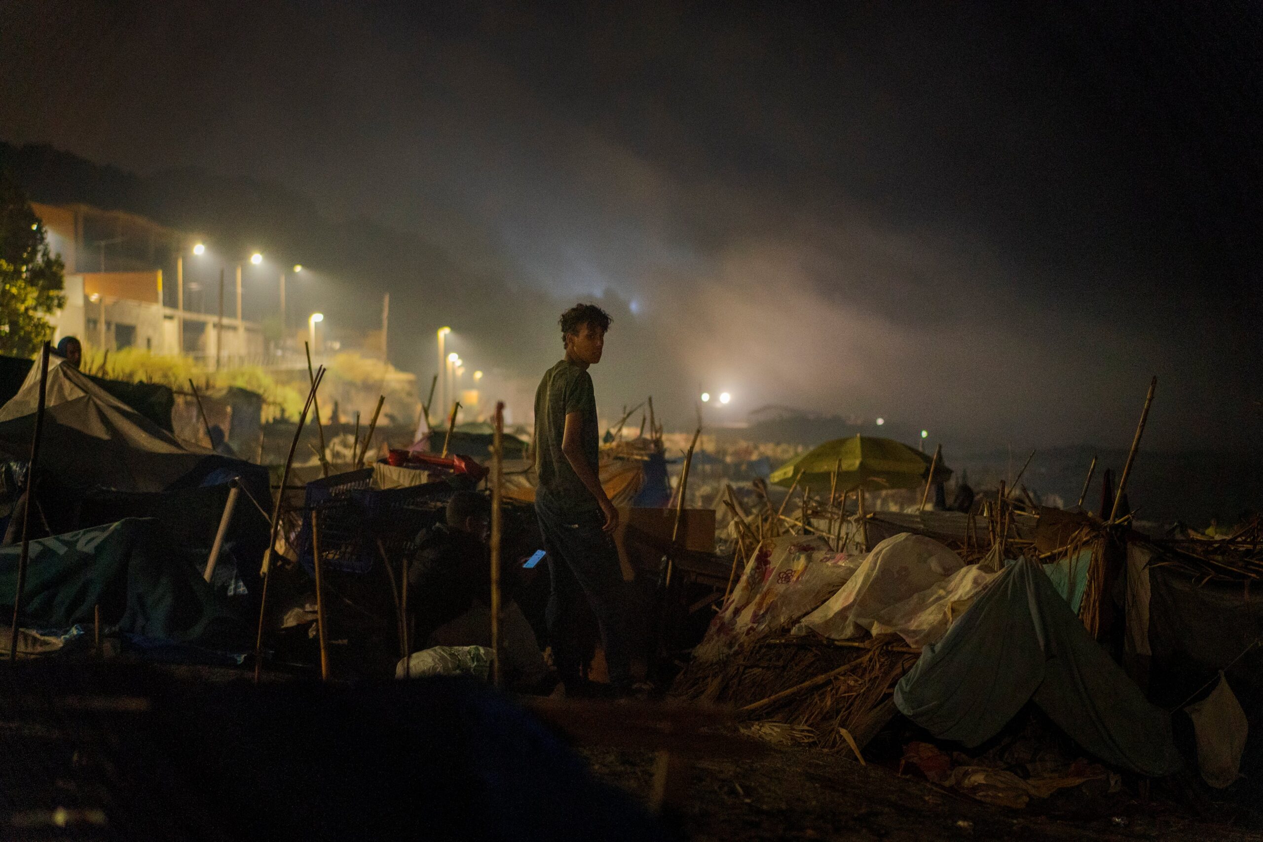 Un joven, en el campamento de chabolas de la playa del Trampolín en la madrugada del 14 al 15 de septiembre.