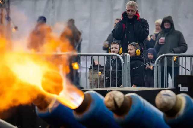 En Ommen, Países Bajos, unos bidones de leche disparan balones de fútbol con grandes llamaradas ante la mirada de las familias.