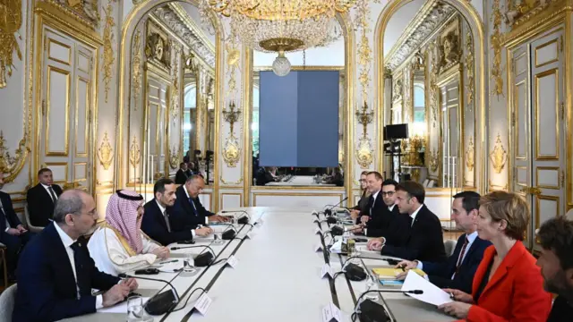 El presidente de Francia, Emmanuel Macron, el cuarto a la derecha, sentado en una mesa en una reunión con varios representantes de países árabes.