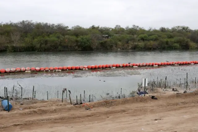 Cadena de boyas naranjas con púas sobre el Río Bravo