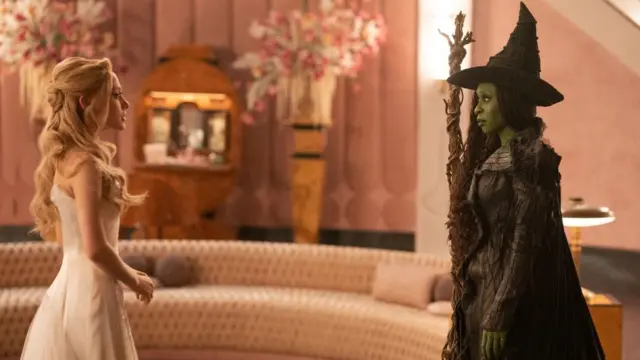 Ariana Grande y Cynthia Erivo en Wicked, de pie una frente a la otra.