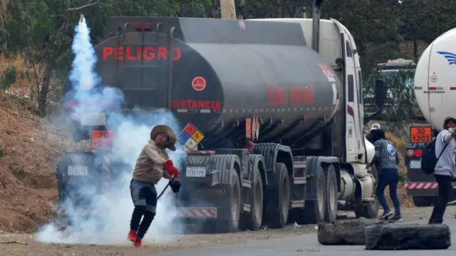 Un hombre lanza piedras a sus adversarios.