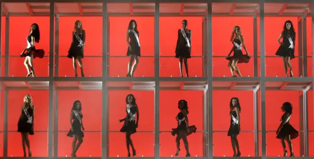 Mujeres en un cubículo enrejado.