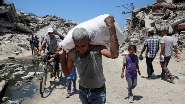Un palestino lleva una bolsa con suministros de ayuda que entraron en Gaza, en Beit Lahia, norte de Gaza, el 27 de julio de 2025.
