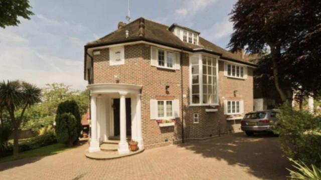 La gran casa en el norte de Londres a la que Jian Wen se mudó en 2017. La imagen muestra una casa de tres plantas con una amplia entrada. Un coche gris está aparcado junto a la casa, que cuenta con múltiples ventanales.