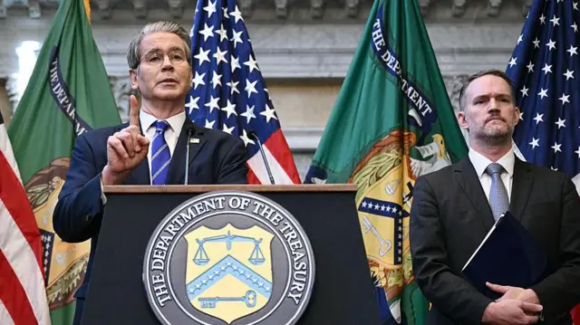 El secretario del Tesoro, Scott Bessent, y el representante comercial, Jamieson Greer, responden preguntas de la prensa en Washington D. C. Ambos hablan tras un atril con una placa prominente del Departamento del Tesoro de EE. UU.