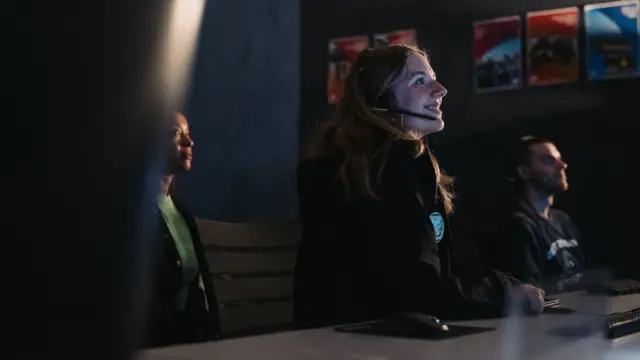 Personas dentro de un centro de comando espacial. 