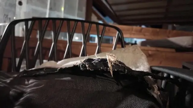 Un asiento descosido adentro de un bar oscuro