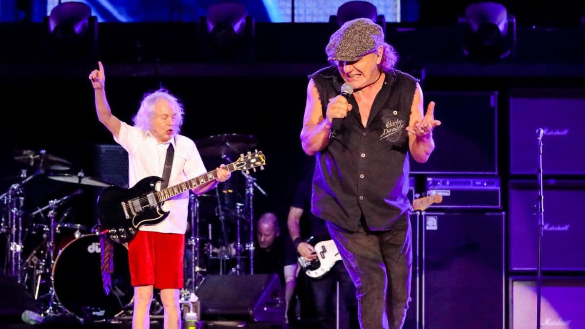 Angus Young y Brian Johnson cantando en un concierto de AC/DC.