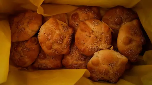 Una bolsa llena de bollitos de pan con semillas.