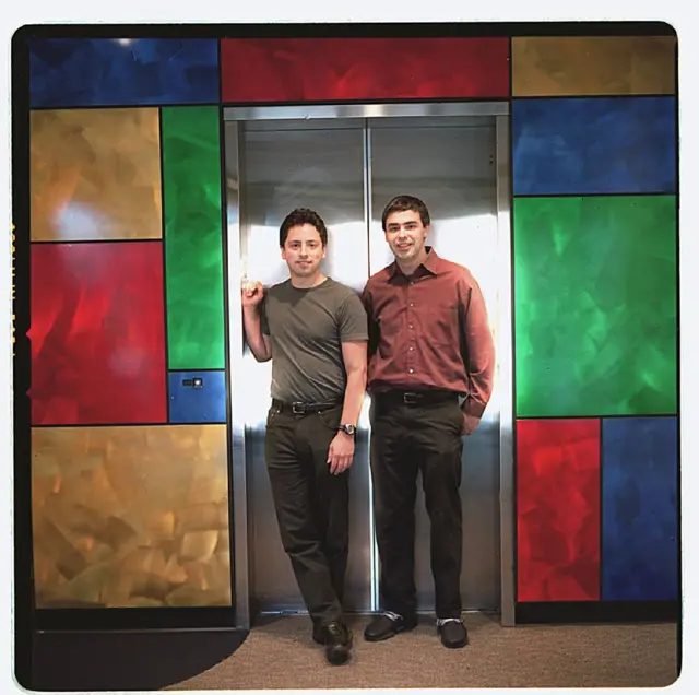 Los fundadores de Google, Sergey Brin (izq), y Larry Page, en el ascensor de la oficina de la empresa en Mt. View en 2003, rodeados por los colores que los identificarían desde la creación del logo 5 años antes.