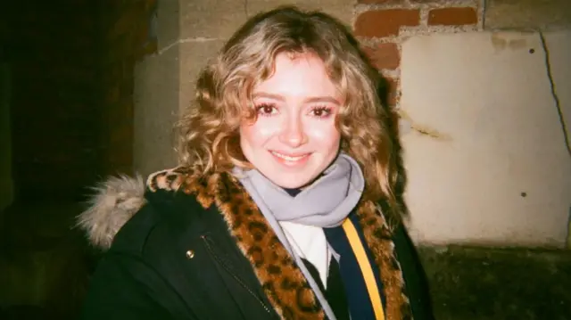 Paloma sonriendo, vestida con una bufanda y chaqueta gruesa