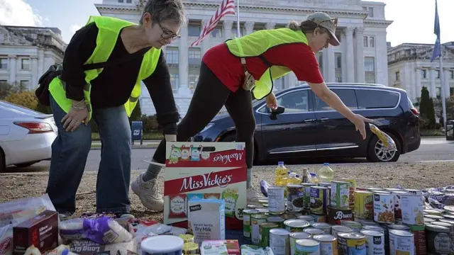 Dos voluntarias inspeccionando latas y paquetes de alimentos donados