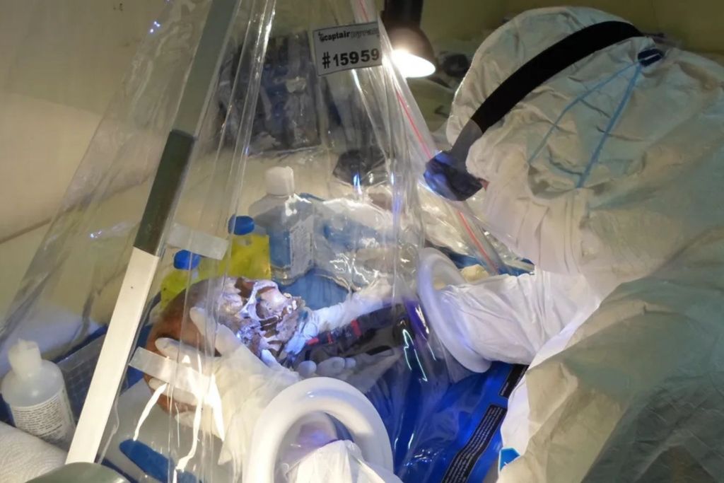 La investigadora Helena Malmström toma una muestra de un cráneo en la estación de investigación de Florisbad utilizando un laboratorio móvil de trabajo limpio