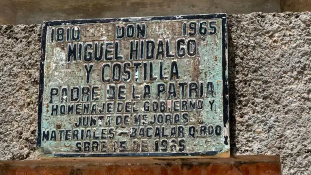 Una placa vieja y desgastada reconoce a Miguel Hidalgo como