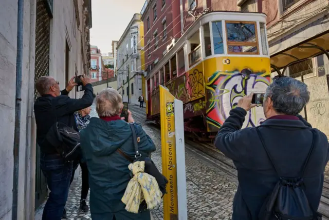 Turistas se fotografían junto a uno de los funiculares en 2024.