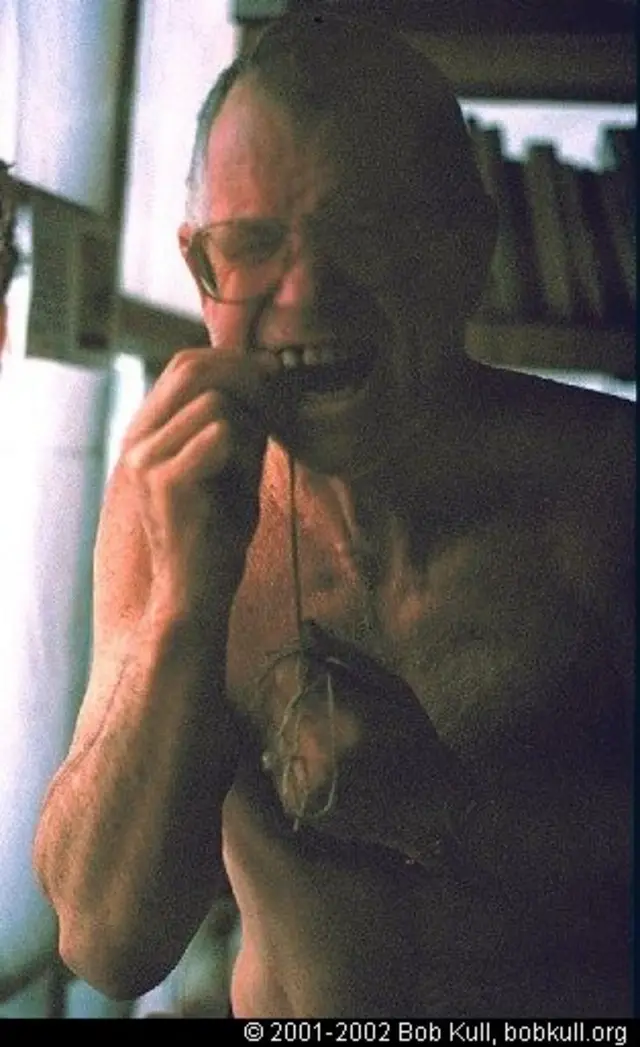 bob kull tratando de extirparse un diente con un hilo 