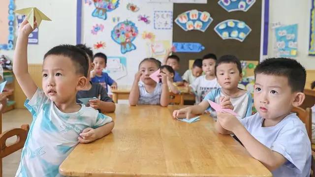 Niños sentados alrededor de una mesa en un salón de clases en Nanchang, China