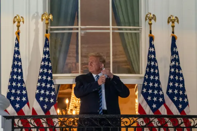 Donald Trump, en el balcón de la Casa Blanca se quita un tapabocas en octubre de 2020