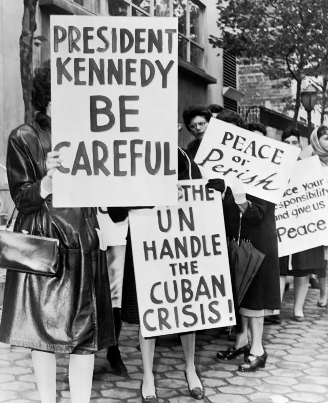 Grupo de mujeres de la Huelga de Mujeres por la Paz sosteniendo carteles relacionados con la crisis de los misiles de Cuba y la paz en Nueva York, en 1962. Eran parte de un grupo más grande de 800 mujeres en huelga por la paz cerca del edificio de Naciones Unidas.