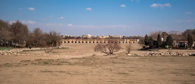 El río seco Zayandeh Rud y el puente histórico Si-o-se-pol (Puente de los 33) en Isfahán, Irán, el 22 de febrero de 2025. Zayandeh Rud es una de las principales atracciones turísticas de Isfahán, y puentes históricos como este pueden resultar dañados debido al hundimiento del lecho del río Zayandeh Rud.