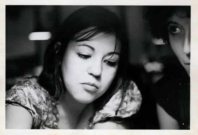 Una foto en blanco y negro de Mariona de joven, con pelo oscuro y mirando hacia abajo. 