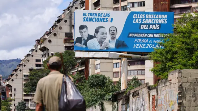 Una valla en Caracas muestra las caras de políticos opositores y la leyenda 