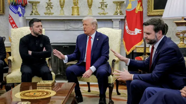 El presidente de Ucrania, Volodymyr Zelensky (izq.) con las manos cruzadas, reunido en la Oficina Oval con el presidente de EE.UU., Donald Trump (centro) y su vicepresidente  JD Vance (der.) Los tres están sentados y Trump y Vance gesticulan con la mano en desagrado hacia Zelensky