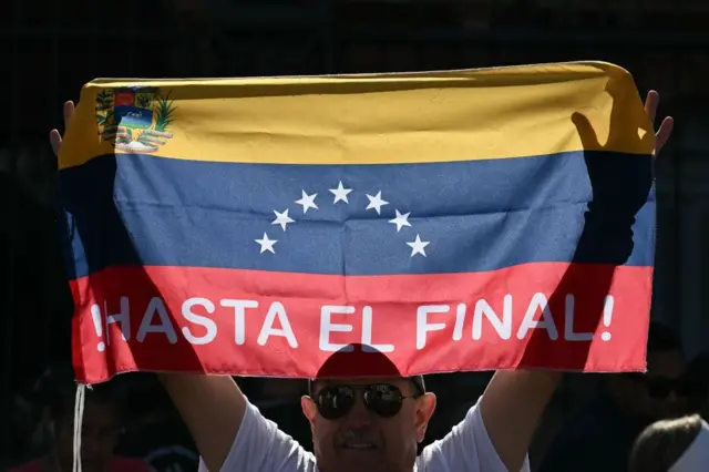 Un hombre con una bandera de Venezuela