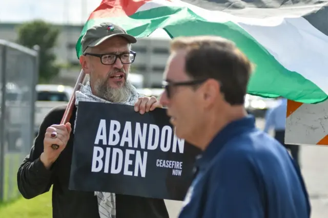 Protesta contra la política de Biden ante la guerra en Gaza. Un hombre porta un cartel que dice