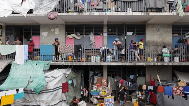 Una escuela que se utiliza como refugio, con gente parada en balcones, ropa tendida y refugios improvisados ​​hechos con lonas, en Puerto Príncipe, octubre de 2025.