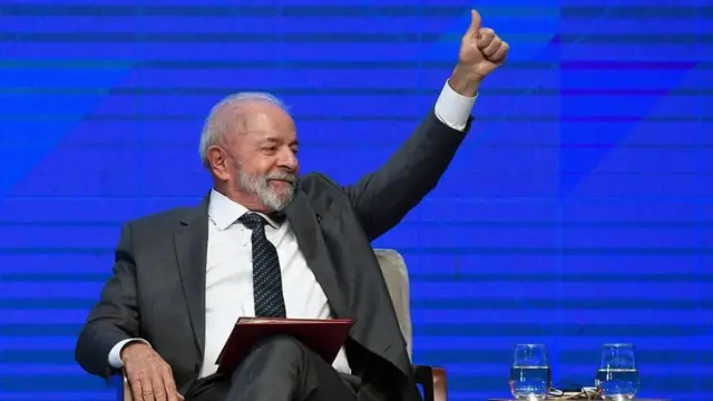 Luis Inacio Lula da Silva, sentado en una silla, con el pulgar izquierdo al aire