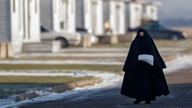 Una mujer miembro del grupo Lev Tahor camina con su vestimenta tradicional por las calles de Ontario. 