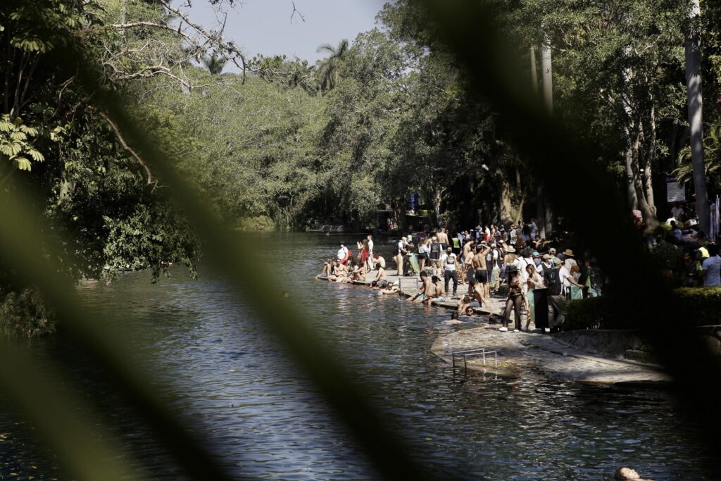 Personas bailando a la orilla del río en el festival Bahidorá.