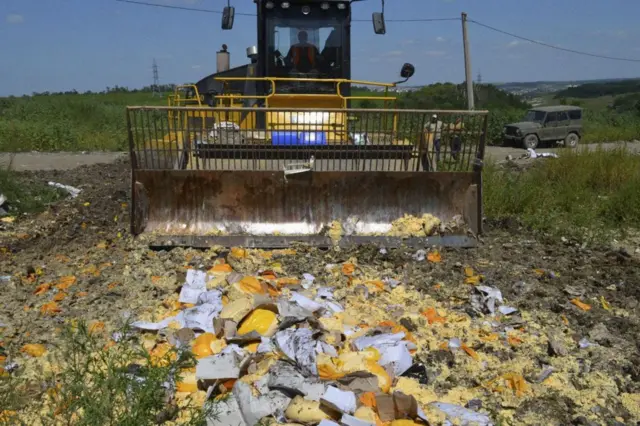 Un tractor recoge restos de quesos que fueron confiscados