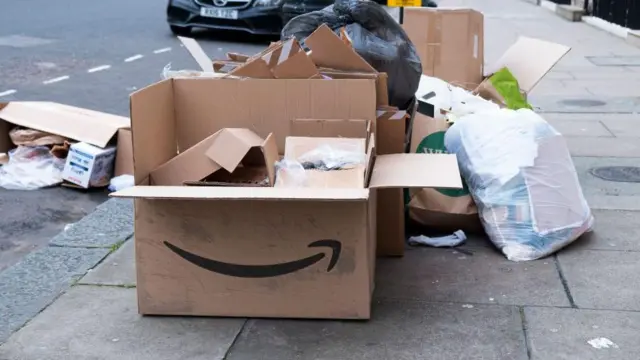 Cajas de basura en la calle con el logo de Amazon