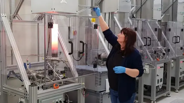 Mujer trabajando con los hornos para fabricar cZT
